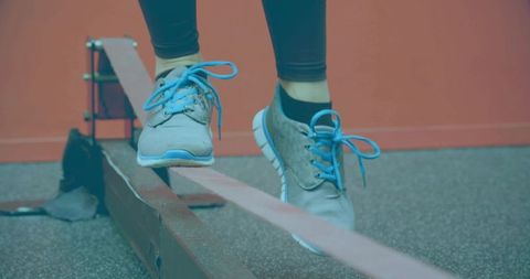 Woman Balancing on Slackline in Fitness Studio with Blue Sneakers