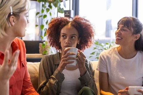 Diverse Female Friends Engaging in Lively Conversation by City Windows