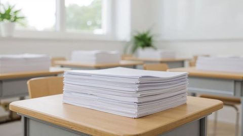 Stack of Papers on Desk in Classroom with Natural Light