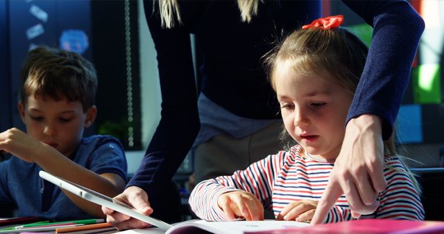 Teacher Assisting Young Students in Classroom During Activity - Download Free Stock Images Pikwizard.com