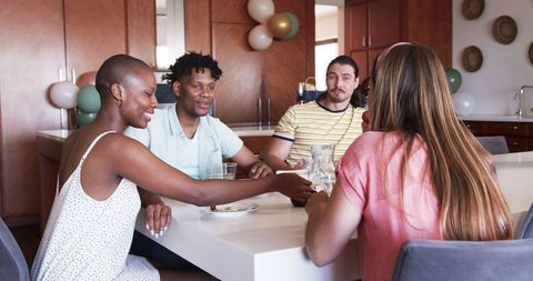 Diverse Group of Friends Sharing Meal and Laughter at Home