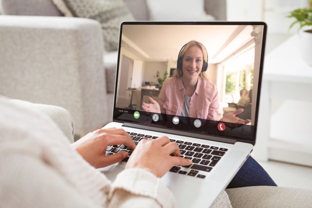 Caucasian women engaged in a video conference call, discussing work from home. Ideal for illustrating remote working, home office settings, business meetings, and digital communication in modern workplaces. Useful for blogs or articles about telecommuting, work-life balance, and virtual collaboration tools.