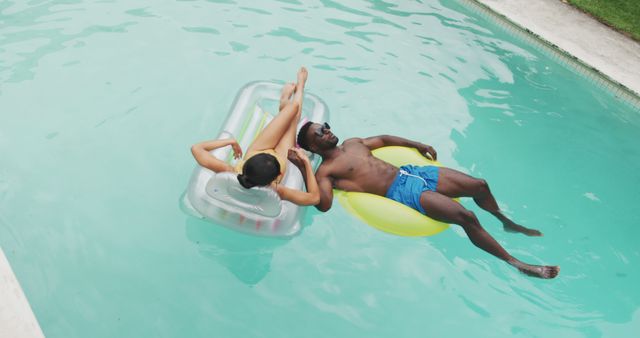 Couple Relaxing on Pool Floats Under Sun - Download Free Stock Images Pikwizard.com