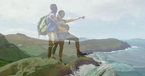 Couple hiking on cliff overlook enjoying breathtaking ocean view