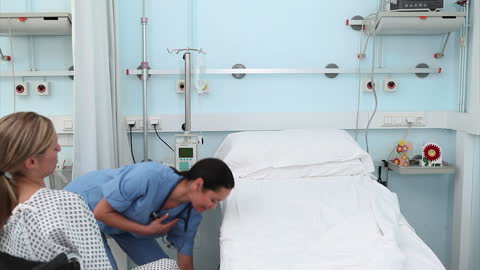 Nurse Caring for Patient in Hospital Ward with Gentle Attention