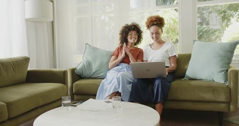 African American Friends Collaborating on Laptop and Smartphone in Sunlit Living Room