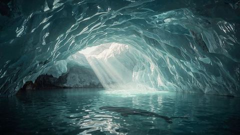 Sunlight streams illuminating tranquil arctic ice cave