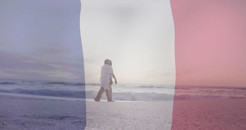 Senior Biracial Couple Walking on Beach with French Flag Overlay