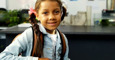 Confident Young Girl in Classroom with Backpack Smiling - Download Free Stock Images Pikwizard.com