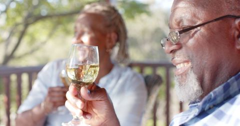 Senior Couple Enjoying Wine on Sunlit Porch Relaxing in Nature - Download Free Stock Images Pikwizard.com