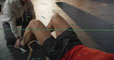 Performing situps with partner bracing feet and digital glitch overlay in gym workout