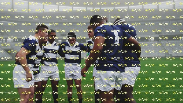 Rugby players wearing blue and white uniforms huddle on a green field before a match. Abstract geometric shapes and light effects are layered over the scene. This dynamic mix can be used for themes of sportsmanship, teamwork, strategy, and digital innovation. Excellent for sports blogs, team strategy content, and technology-focused projects integrating physical sports and digital effects.