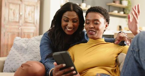 Diverse friends enjoying time together sharing smartphone content