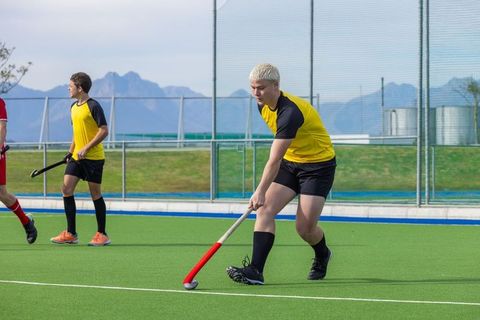 Field hockey players compete on green turf
