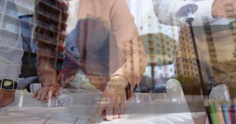 Architects collaborating on blueprints in modern urban development office