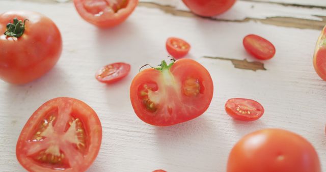 Image of fresh halved and whole red tomatoes on white rustic background - Download Free Stock Photos Pikwizard.com