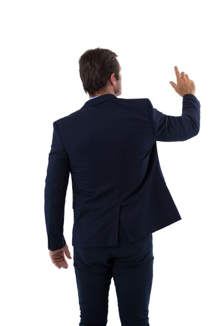 Rear view of businessman pressing an invisible virtual screen against white background