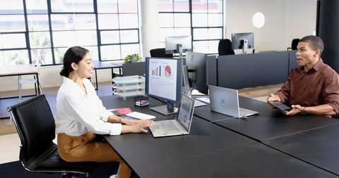 Colleagues discussing business plans in modern office environment