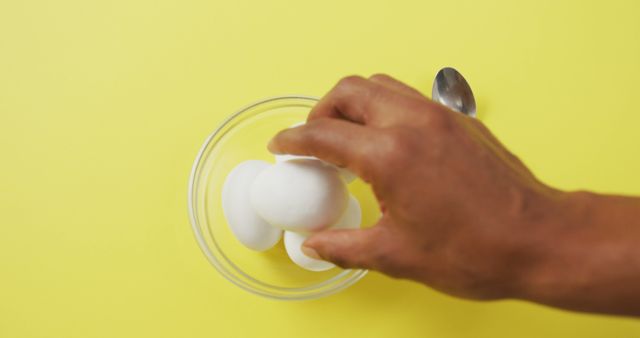 Person Grabbing Eggs from Bowl on Bright Yellow Background - Download Free Stock Images Pikwizard.com