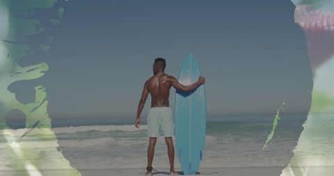 Surfer Holding Surfboard Watching Ocean Waves on Beach