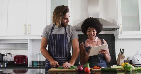 Couple Cooking in Kitchen Using Digital Tablet
