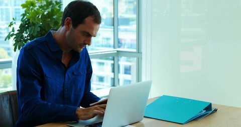 Businessman Working on Laptop in Modern Office with City View - Download Free Stock Images Pikwizard.com