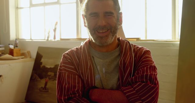 Smiling middle-aged artist in studio with sunlight - Download Free Stock Images Pikwizard.com