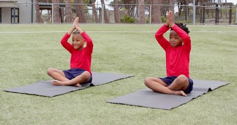 Young Boys Practicing Yoga Outdoors on Mats