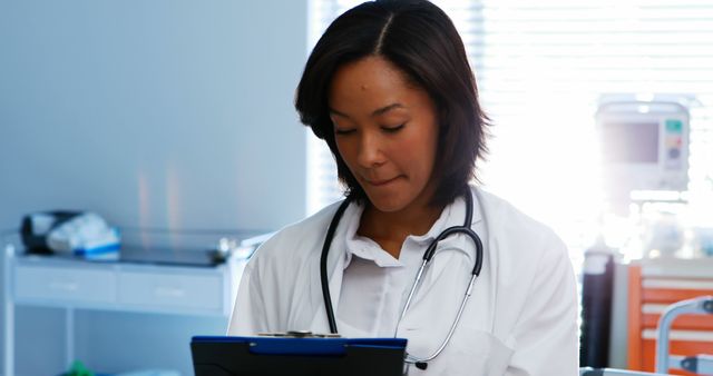 Focused Female Doctor Writing on Clipboard in Medical Office - Download Free Stock Images Pikwizard.com