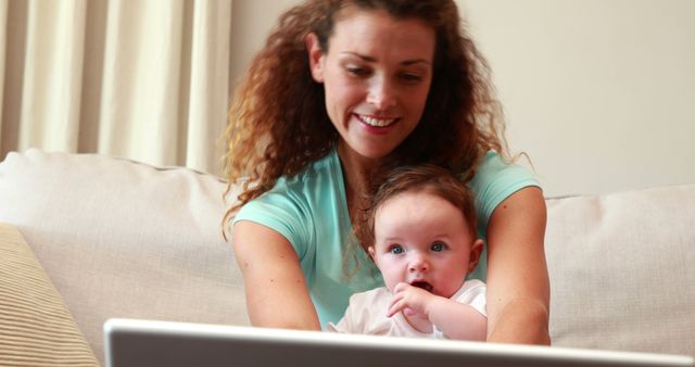 Mother Working Remotely with Baby in Arms on Couch - Download Free Stock Images Pikwizard.com