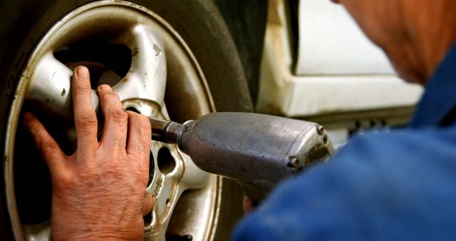 Mechanic Using Impact Wrench to Fix Car Tire - Download Free Stock Images Pikwizard.com