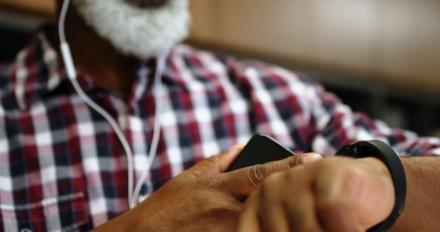 Senior Black Man Using Smartphone and Smartwatch with Earphones - Download Free Stock Images Pikwizard.com