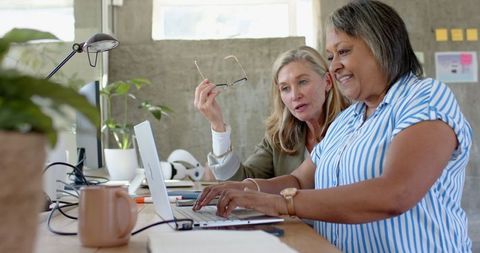 Diverse Female Colleagues Collaborating at Modern Office Workspace