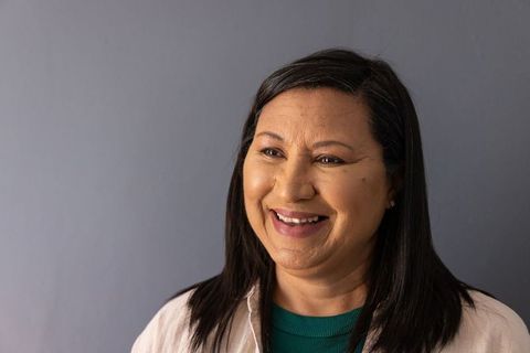 Warm smiling mature woman headshot conveying trust and friendliness for business and care