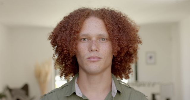 Portrait of caucasian man with ginger curly hair and freckles at sunny home. Lifestyle and domestic life, unaltered.