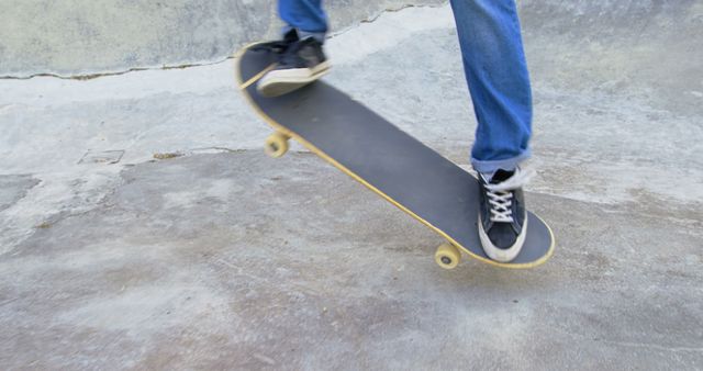 A skateboarder is performing a trick on a skate park ramp, showcasing balance and skill. Suitable for illustrating outdoor activities, urban lifestyle, youth culture, and sport-related content. Can be used for advertising related to skateboarding equipment, sports apparel, and hobby interests.