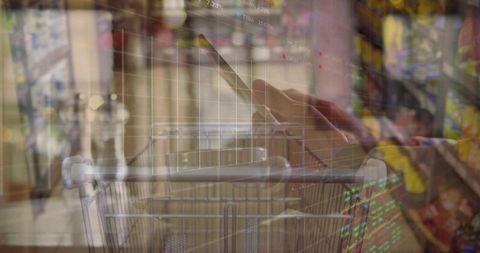 Shopper using smartphone while pushing cart overlaying stock market graphs financial data
