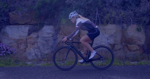 Female Cyclist Riding on Rocky Mountain Road