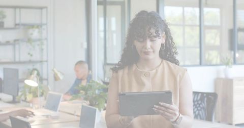Businesswoman holding tablet and checking data in bright modern coworking office