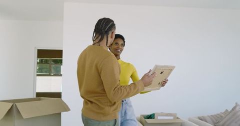Couple unpacking boxes together in modern living room