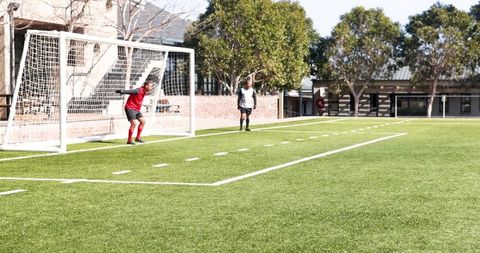 Goalkeeper Preparing to Block Shot on Sunny Soccer Field