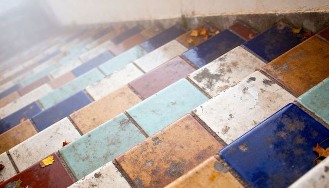 Colorful Weathered Ceramic Staircase with Worn Glazed Tiles and Autumn Leaves Outdoor