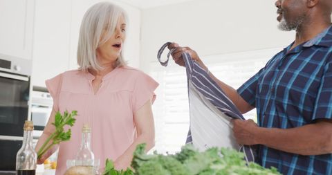 Senior Couple Preparing Meal Together in Modern Kitchen