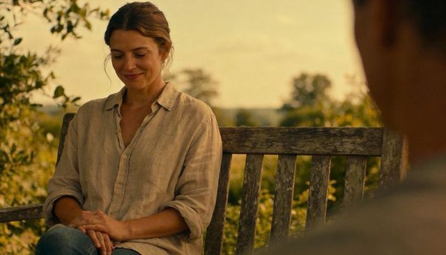 Woman relaxing on weathered bench during golden hour in idyllic countryside portrait