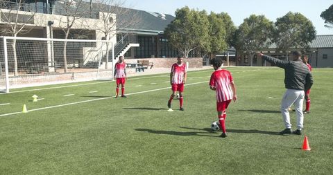 Teen Soccer Players Practicing Drills on School Field