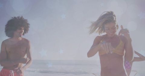 Carefree Friends Dancing on Sunlit Beach