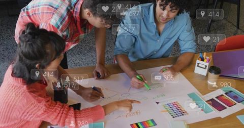 Creative team brainstorming and sketching design ideas on large paper with markers