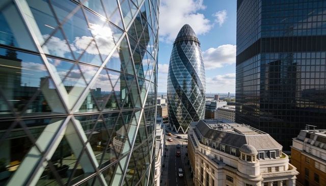 Gherkin tower rising between reflective glass giants in london financial district skyline