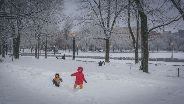 Children playing in deep snow at urban park wearing bright winter coats under street lamps