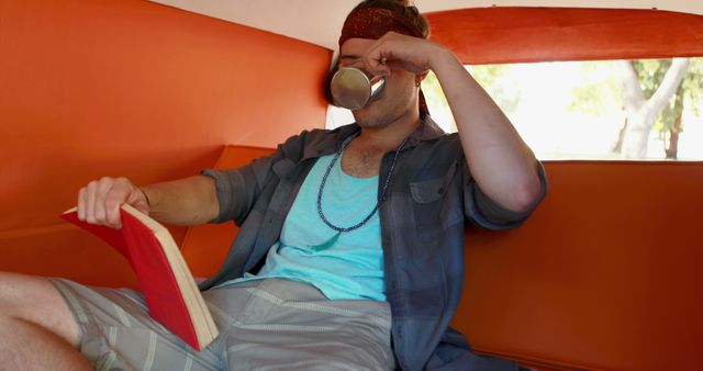 Relaxing Young Man Reading Book and Drinking Coffee in Bright Room - Download Free Stock Images Pikwizard.com